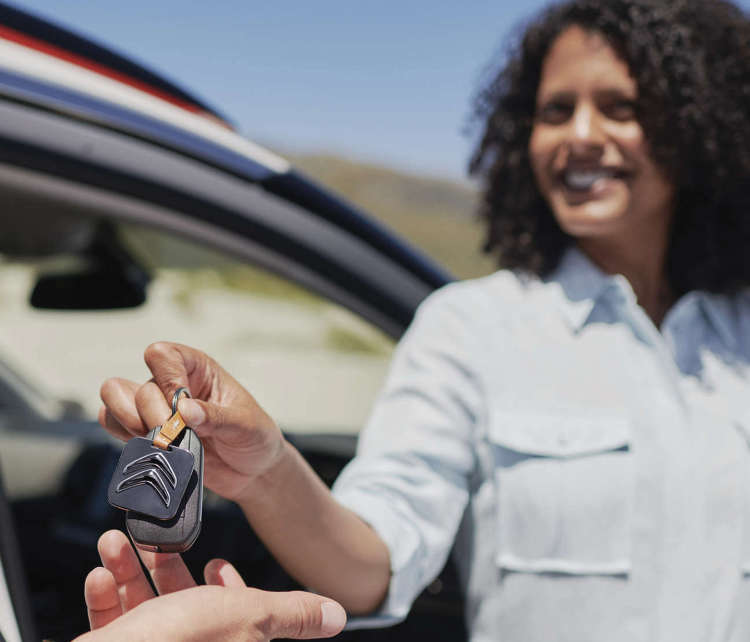 Молода жінка передає клієнту ключі від автомобіля Citroën