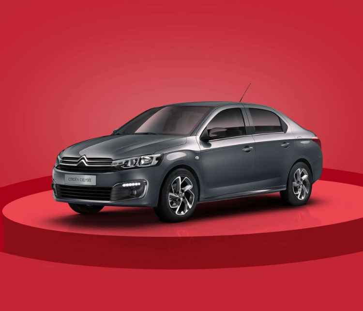 Вигляд спереду з лівого боку на Citroën C-Elysée на червоному фоні