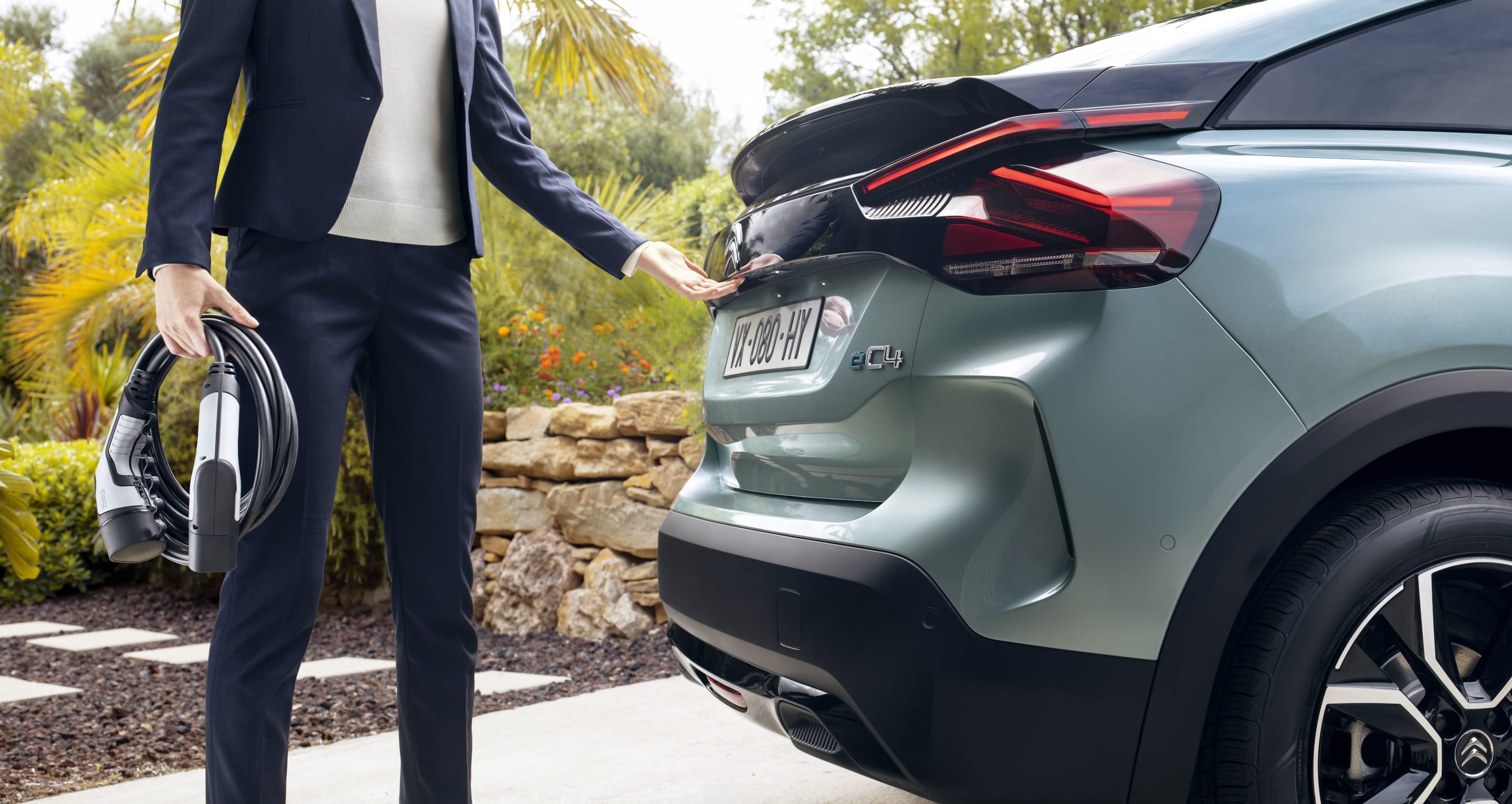 Чоловік з електричним зарядним кабелем біля Citroen e-C4