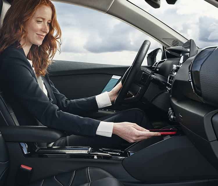 Жінка-водія користується консоллю у салоні Citroen C4